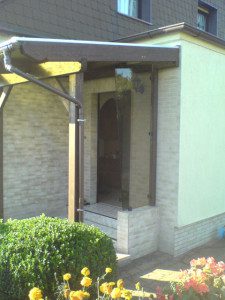 Vordach aus Massivholz mit seitlich eingefasster Glasscheibe